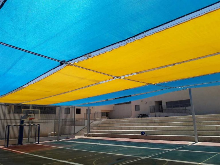 רשת נעה על כבלים בשילוב צבעים של טורקיז וצהוב מעל מגרש כדורסל