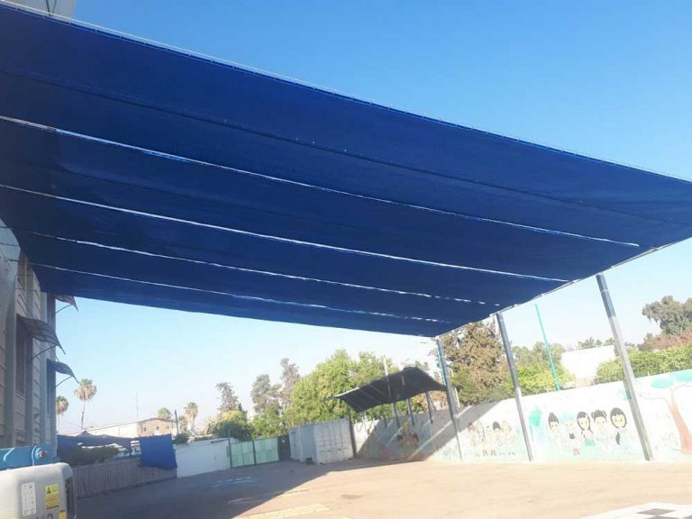 רשת הצללה 320 גר נעה על כבלים, מותקנת בעזרת קרבינות על כבלים בין מבנה לעמודים